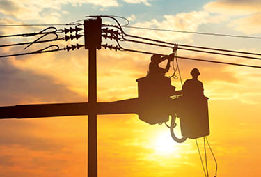 Silhouette electrician work at height on crane to make electrical connections. High voltage electrical system.